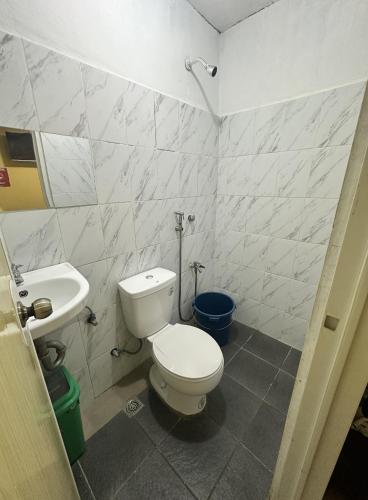 a bathroom with a white toilet and a sink at Don Pedro in Tacloban