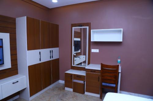 a bathroom with a sink and a mirror at Raj Hussain Land Mark Hotel in Mayiladuthurai