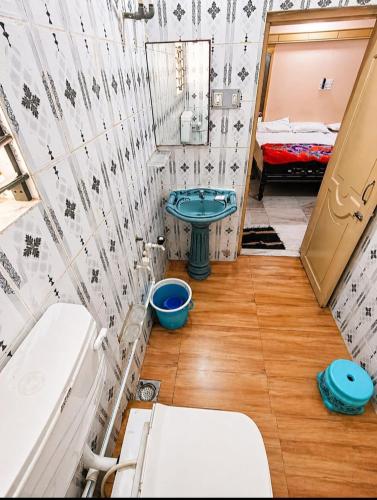 a small bathroom with a toilet and a sink at Evergreen AC Bunglow in Dwarka
