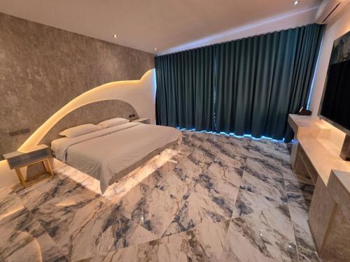 a bedroom with a bed and a flat screen tv at Dream View Villa Samal in Samal