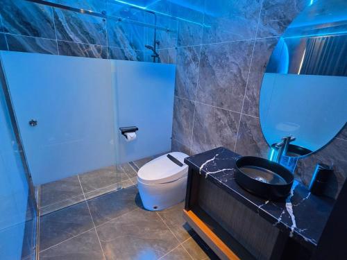 a bathroom with a toilet and a sink and a mirror at Dream View Villa Samal in Samal