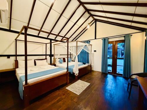 a bedroom with a canopy bed and a wooden floor at Walawa Reach hotel in Udawalawe