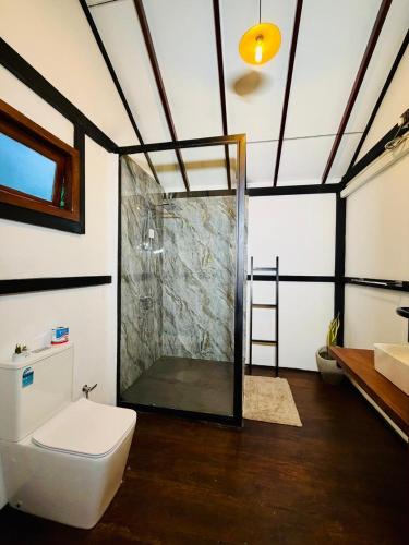 a bathroom with a shower and a toilet and a sink at Walawa Reach hotel in Udawalawe