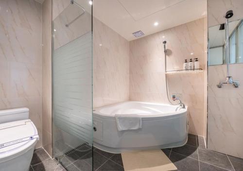 a bathroom with a shower and a tub and a toilet at Gimpo Pentastar Hotel in Gimpo