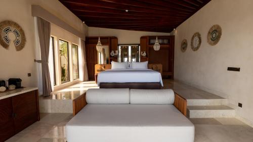 a bedroom with two beds and two windows at Vanara Resort and Spa in Uluwatu