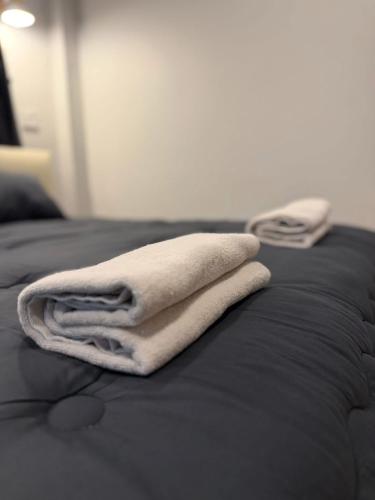a white towel sitting on top of a bed at ภูไทโฮมสเตย์ บ้านกุดหว้า in Ban Don Um Lua