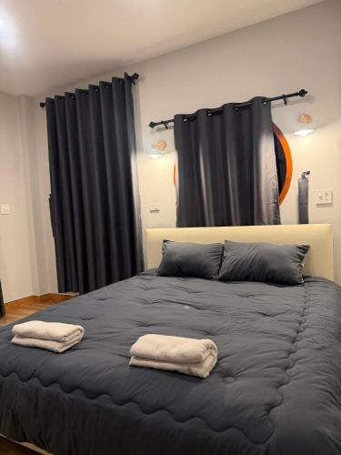 a bedroom with a bed with two towels on it at ภูไทโฮมสเตย์ บ้านกุดหว้า in Ban Don Um Lua
