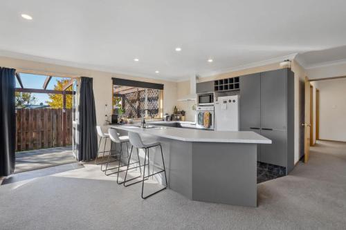a kitchen with a counter and stools in it at Haven on Molyneux in Cromwell