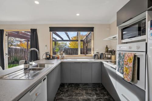 a kitchen with a sink and a large window at Haven on Molyneux in Cromwell
