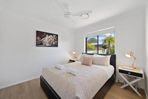a bedroom with a bed with a desk and a window at Rundle & Salt in Ulladulla