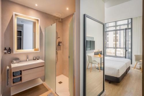 a bathroom with a sink and a bedroom with a bed at INNSiDE by Meliá Madrid Gran Vía in Madrid