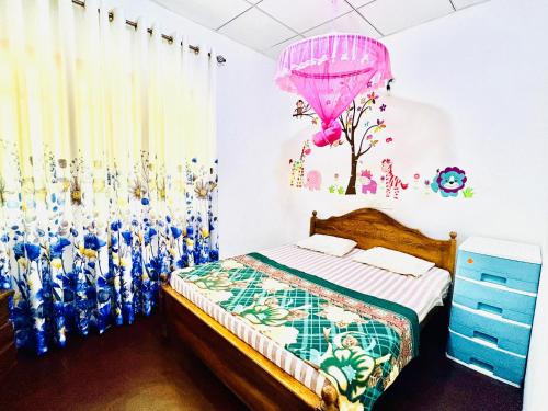 a bedroom with a bed and a pink balloon at Oli Guest House in Diyatalawa