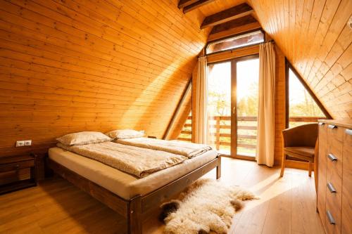 a bedroom with a bed in a wooden wall at Lunor House in Izvoare