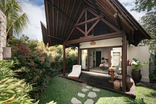 a villa with a sitting area in a garden at ALMA SHANTI Boutique Hotel in Uluwatu