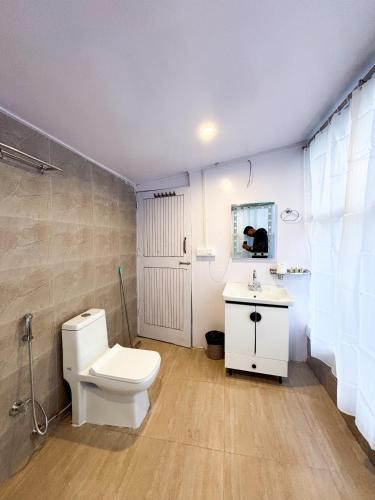 a bathroom with a white toilet and a sink at jibhihomesteadcabin in Jibhi