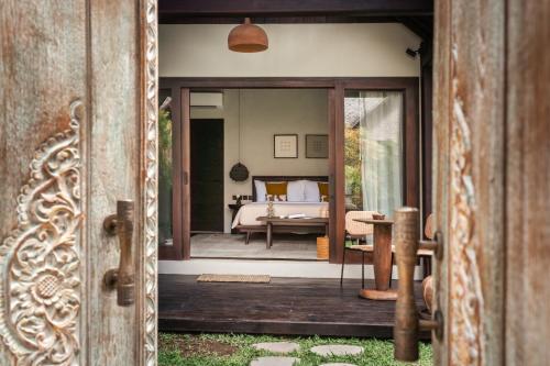 an open door to a bedroom with a bed at ALMA SHANTI Boutique Hotel in Uluwatu