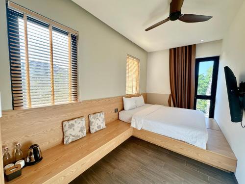 a bedroom with a bed and a large window at SOLEIL HOSTEL in Hue