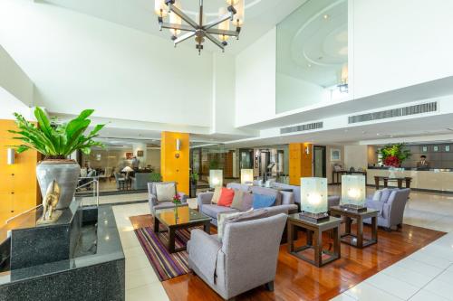 a lobby with chairs and tables in a building at Kantary House Hotel, Bangkok in Bangkok