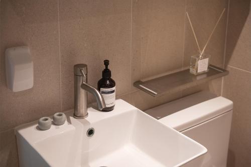 a bathroom sink with a bottle of wine on it at 서울역 2분거리, 클레어맨션 201 in Samgong