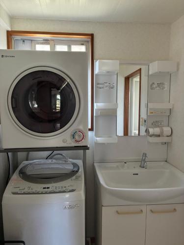 a bathroom with a washing machine and a sink at 本部コテージnobaru in Motobu