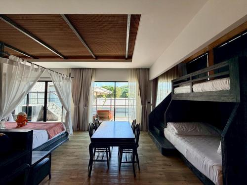 a bedroom with two bunk beds and a blue table at Ananya Lipe Resort in Ko Lipe