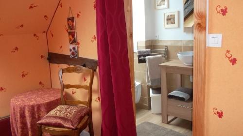 a bathroom with a toilet and a chair in it at La tuilerie-Les Champs du Possible in Saligny-sur-Roudon
