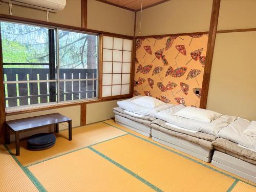 a room with a couch and a table and windows at Tanigawa Valley Lodge & Coffee Roastery in Minakami