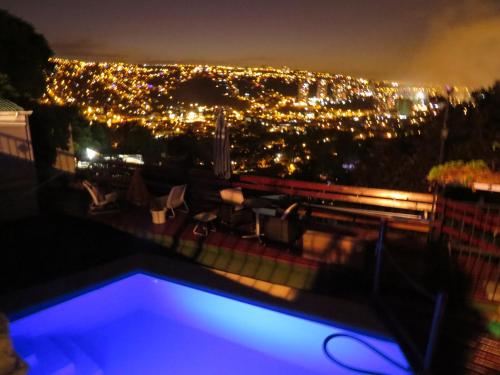 a swimming pool with a view of a city at night at Posada Verde Natura in Viña del Mar
