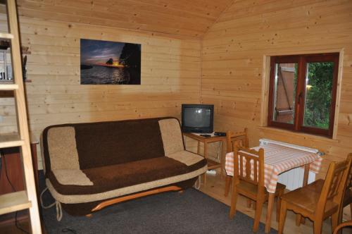 a living room with a couch and a table and a television at Porębówka in Szczawnica