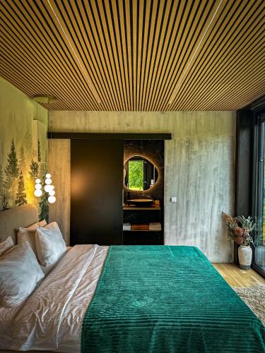 a bedroom with a large bed with a wooden ceiling at Forest Chalet in Porumbacu de Sus