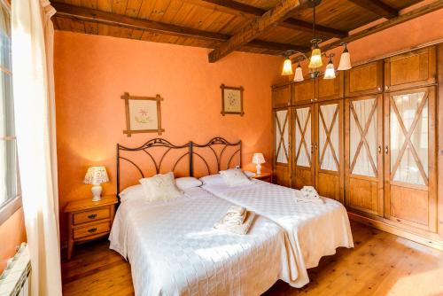 a bedroom with a large bed with white sheets at Los Montejos & Spa in Valverde del Fresno