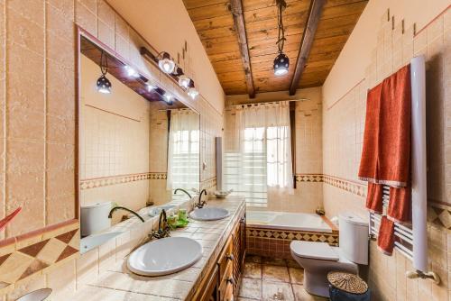 a bathroom with two sinks and a tub at Los Montejos & Spa in Valverde del Fresno