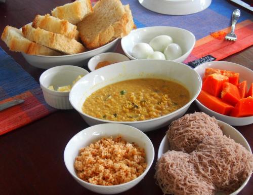 a table with bowls of food on a table at Tea Vibe Bungalow Malwatte in Bandarawela