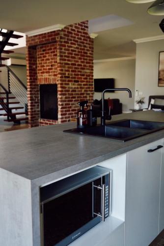 a kitchen with a counter with a sink and a fireplace at Lusso - Boutique Accommodation in Whitfield