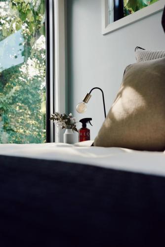 a bedroom with a bed with a lamp and a window at Lusso - Boutique Accommodation in Whitfield