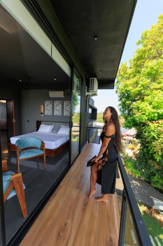 a woman is standing on the balcony of a house at Secret Paradise Edge in Weligama