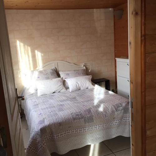 une chambre avec un lit avec des draps blancs et des oreillers dans l'établissement Lachanau Paradis, à Hourtin