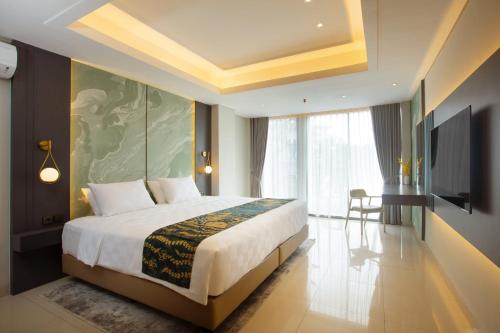 a bedroom with a large bed and a television at Louis Kienne Reserve Cikarang in Cikarang