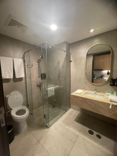 a bathroom with a shower and a toilet and a sink at Louis Kienne Reserve Cikarang in Cikarang