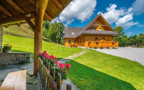 una casa de madera con flores delante en Chata Škerda - Zuberec en Zuberec