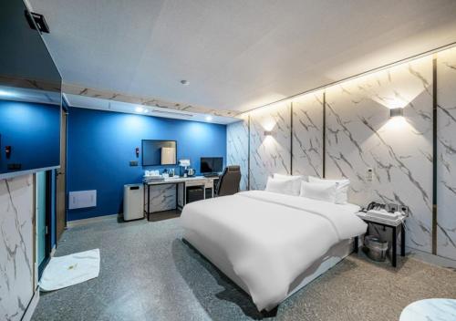 a bedroom with a large white bed and a desk at G7 Hotel in Tongduch'ŏn