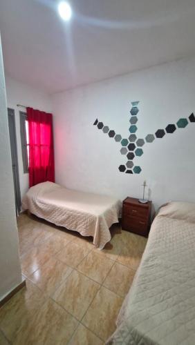 a bedroom with two beds and a wall at Dpto 6 in La Cieneguita