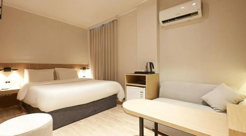a hotel room with two beds and a couch at sotam stay hotel in Taeam