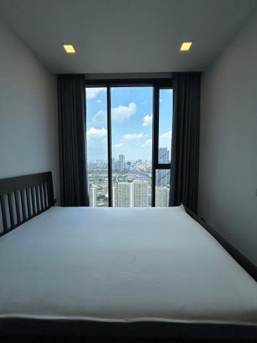 a bedroom with a large bed and a large window at One9Five Asoke 可月租 in Ban Hui Yai Muk