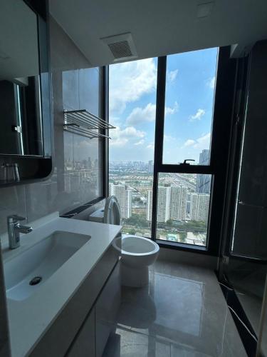 a bathroom with a sink and a toilet and a large window at One9Five Asoke 可月租 in Ban Hui Yai Muk