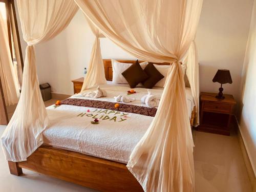 a bedroom with a bed with curtains and flowers on it at Dika Homestay in Sidemen