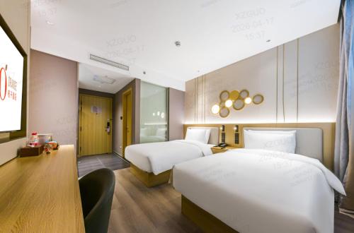 a hotel room with two beds and a desk at Orange Hotel Shanghai Wuzhong Road Metro Station in Shanghai