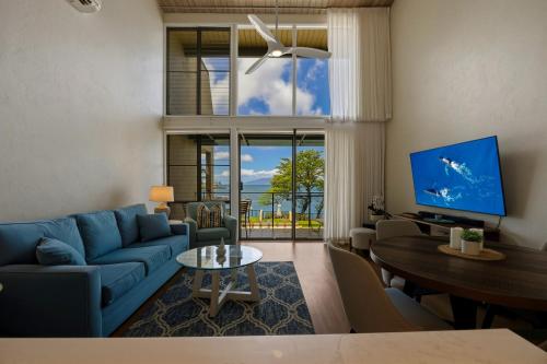 a living room with a blue couch and a table at Prime Oceanfront 2BR Loft - Unit C10 condo in Lahaina