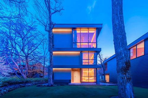a house with lights on the side of it at JADE D Plus and E Plus Hakuba in Hakuba