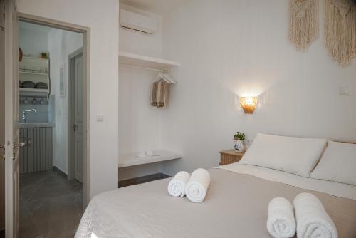 a bedroom with a white bed with towels on it at Limonletto in Patmos